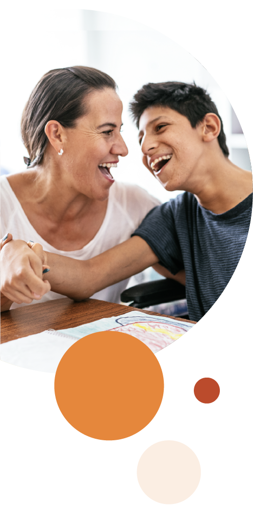 Woman and boy smiling together at a table.